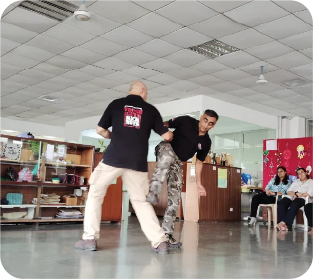 Trainer demonstrating escape techniques with participant in practice session